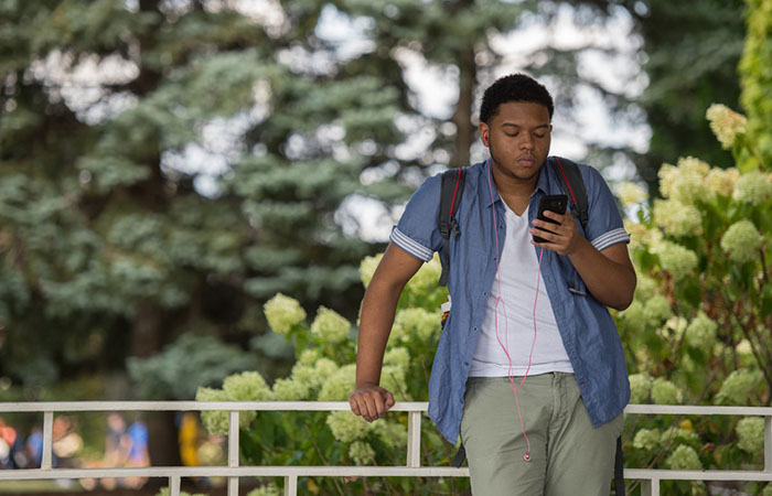 Student using a cell phone to connect online